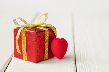 gift box and red hearts on wooden light background valentine's day