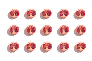 Symmetrical composition of pomegranate slices on white background. Top view.
