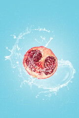 Pomegranate slice with water splash isolated on blue blackground. © Miguel Tamayo 