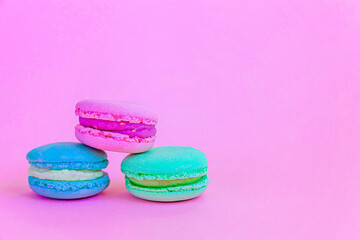 Fototapeta na wymiar Sweet almond colorful unicorn blue green pink macaron or macaroon dessert cake isolated on trendy pink pastel background. French sweet cookie. Minimal food bakery concept Copy space
