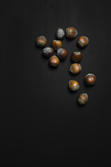 vertical photo of fresh hazelnuts on the top on black background. top view. put your text. wallpaper