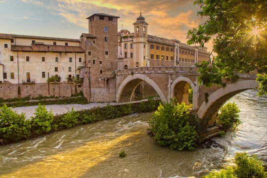 Fabricius Bridge and the Tiber Island at sunset in Rome. The Pons Fabricius or Ponte dei Quattro Capi, is the oldest Roman bridge in Rome, Italy