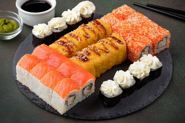 Set of sushi rolls on a dark green background. Japanese oriental cuisine