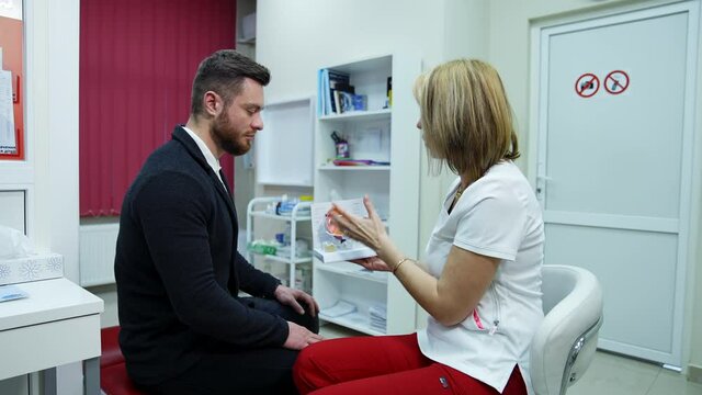 Doctor and client talking in ophthalmological office. Professional optician giving advice to a male patient on an eye dummy using lenses.