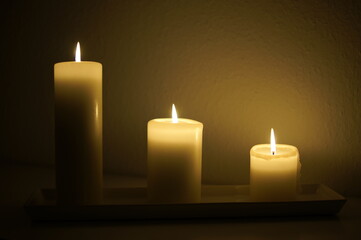 Fototapeta na wymiar Three candles burning in the dark