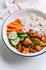 Healthy bowl with Chicken meat, rice and vegetables in a white plate on the table.