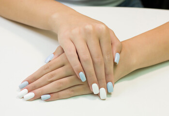 Obraz na płótnie Canvas two-tone manicure with blue and white nail Polish