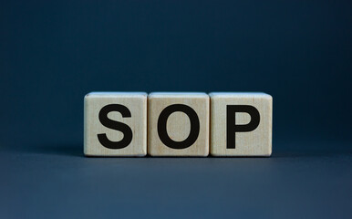 SOP - standard operations procedure symbol. Concept word 'SOP - standard operations procedure' on cubes on a beautiful grey background. Business and SOP concept. Copy space.