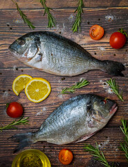 Fresh dorado fish. Dorado and ingredients for cooking on a wooden table.