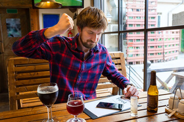 A man fired from his job sits in a bar and drinks a strong alcoholic beverage. The man is depressed, in despair. Alcoholism, the fight against alcohol addiction