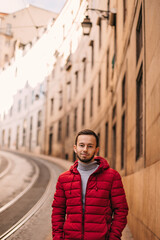 close-up of a bearded guy in a red jacket. man walks the streets