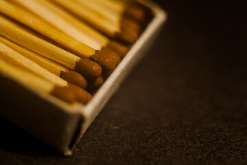 Open box of matches, macro photo, focus on one match. Concept with matches on a dark background