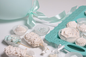 Zephyr on a stick. Marshmallows of different shapes and shades. Close-up shot. On a white table top and a turquoise tray.