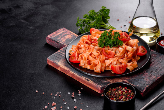Delicious fresh paste with tomato sauce with spices and herbs on a dark background