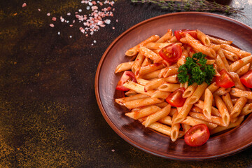 Delicious fresh paste with tomato sauce with spices and herbs on a dark background