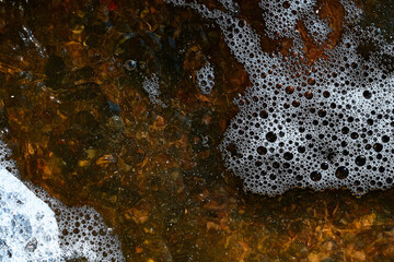 Foam on the water. Dark water.