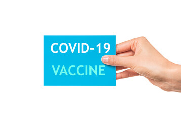 Card with the inscription Covid-19 vaccine in a female hand isolated on white.