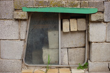 Old homemade design with bus window on the facade wall of cinder block