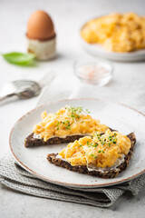 Scrambled egg sandwich with cream cheese on rye toast for breakfast on white background. Healthy breakfast or snack