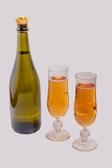 Green bottle with champagne inside and two glasses with champagne 