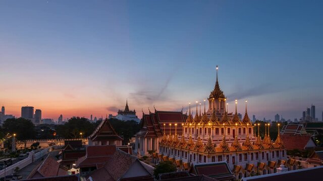 Loha Prasat or Iron Castle Monastery at Wat Ratchanatdaram temple, on Ratchadamnoen Avenue during morning, Bangkok, Thailand; night to day &ndash; time lapse