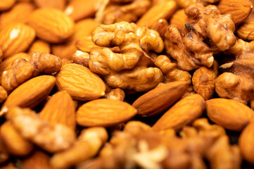 Almonds and walnuts scattered on the table. Close-up, selective focus.