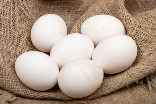Chicken eggs on a background of homespun fabric with a rough texture. Close-up, selective focus.
