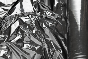 Smooth texture. Black shiny film bag pattern. Wrap transparent dark cellophane background. Real...