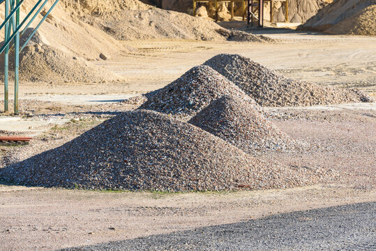 Velt conveyors and a piles of rubble in gravel quarry, crushed sand in different sizes.