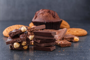 Chocolate cupcake with icing and chocolate bar in Dark lighting,Homemade delicious chocolate muffin on wooden background close-up