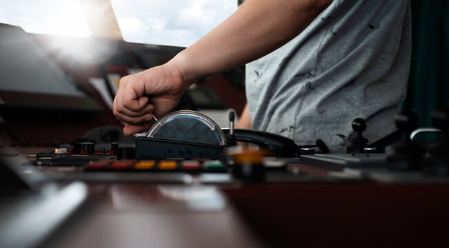 Captain crew officer hand on ship's control bridge dashboard with navigation equipment on the vessel bridge.