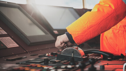 Captain crew officer hand on ship's control bridge dashboard with navigation equipment on the...