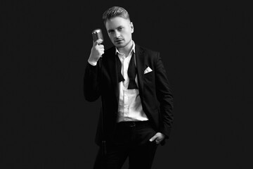 Handsome singer in elegant tuxedo and bow tie with vintage microphone