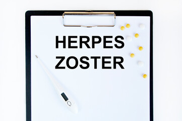 On the letter tablet is the text of Herpes zoster, next to the thermometer and yellow tablets.