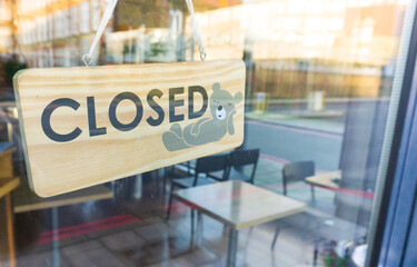 Store sign, closed. Coronavirus sign in a store. empty coffee shop during lockdown.