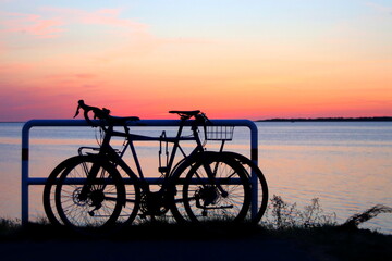 Fototapeta na wymiar Parked bicycles on sea shore. Sunset environment.