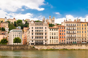 Vieux-Lyon, colorful houses in the center, on the river Saone, with the Fourviere cathedral in background