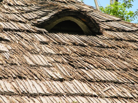 Attic window of an old wooden house decorated with wood carvings fragment - Powered by Adobe