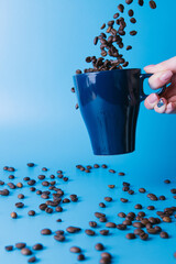 girl scatters coffee from a blue cup on a blue background