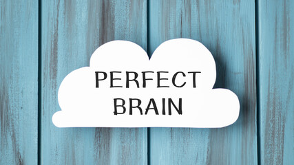 White card in cloud shape with text PERFECT BRAIN on stylish wooden background