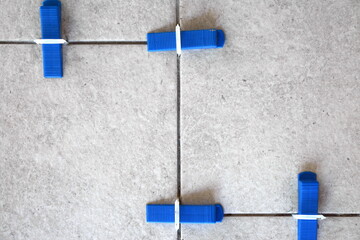 Industrial background. Tile leveling system with plastic clips and wedges, 