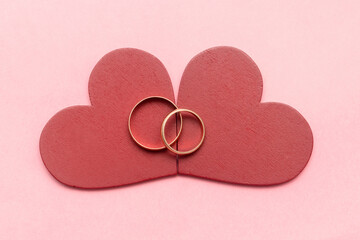 Two wedding rings on red hearts on a pink background. Valentine's Day, engagement, marriage, wedding. love concept.