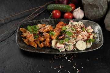 Chicken fillet in honey sauce with sesame seeds and salad from fresh vegetables and sour cream. A hot Asian main course made from poultry, cucumber, tomatoes, radishes, onions, herbs and sour cream.