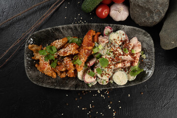 Chicken fillet in honey sauce with sesame seeds and salad from fresh vegetables and sour cream. A hot Asian main course made from poultry, cucumber, tomatoes, radishes, onions, herbs and sour cream.