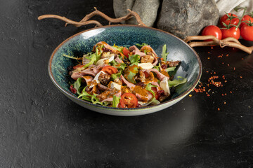 Salad with duck walnuts, prunes and brie cheese. Cold veggie appetizer with arugula, cherry tomatoes, poultry fillets, prunes, cheese and sun-dried tomatoes.