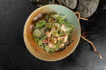 Chicken, mushroom and bacon salad. Cold appetizer with arugula, cucumber, tomato, chicken fillet, bacon and salad dressing.