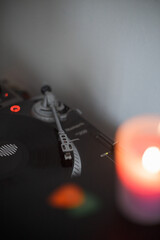 vinyl player with a record, burning candle in the foreground
