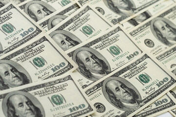 A money pile of one hundred US banknotes with president Franklin portrait. Cash of hundred dollar bills, paper currency background