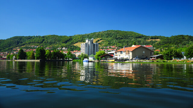 The houses on the shore of the Danube reflecting in the river's calm waters. The hilly region has plenty resorts for a nice summer vacation. Eselnita, Romania.