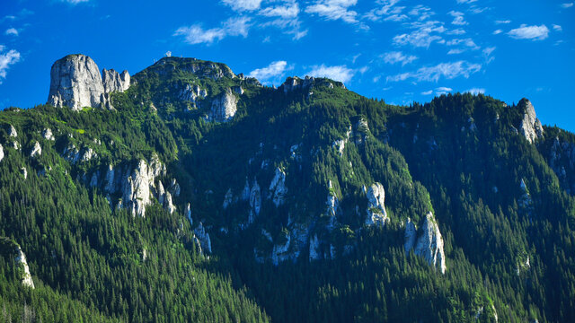 Toaca peak rising iabove the surrounding wild spruce forests. Ceahlau Mountains contain lots of calcareous rocks forming an imposing array of sharps crests. Carpathia, Romania.